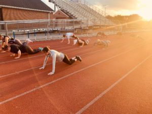 women doing pushups on a track